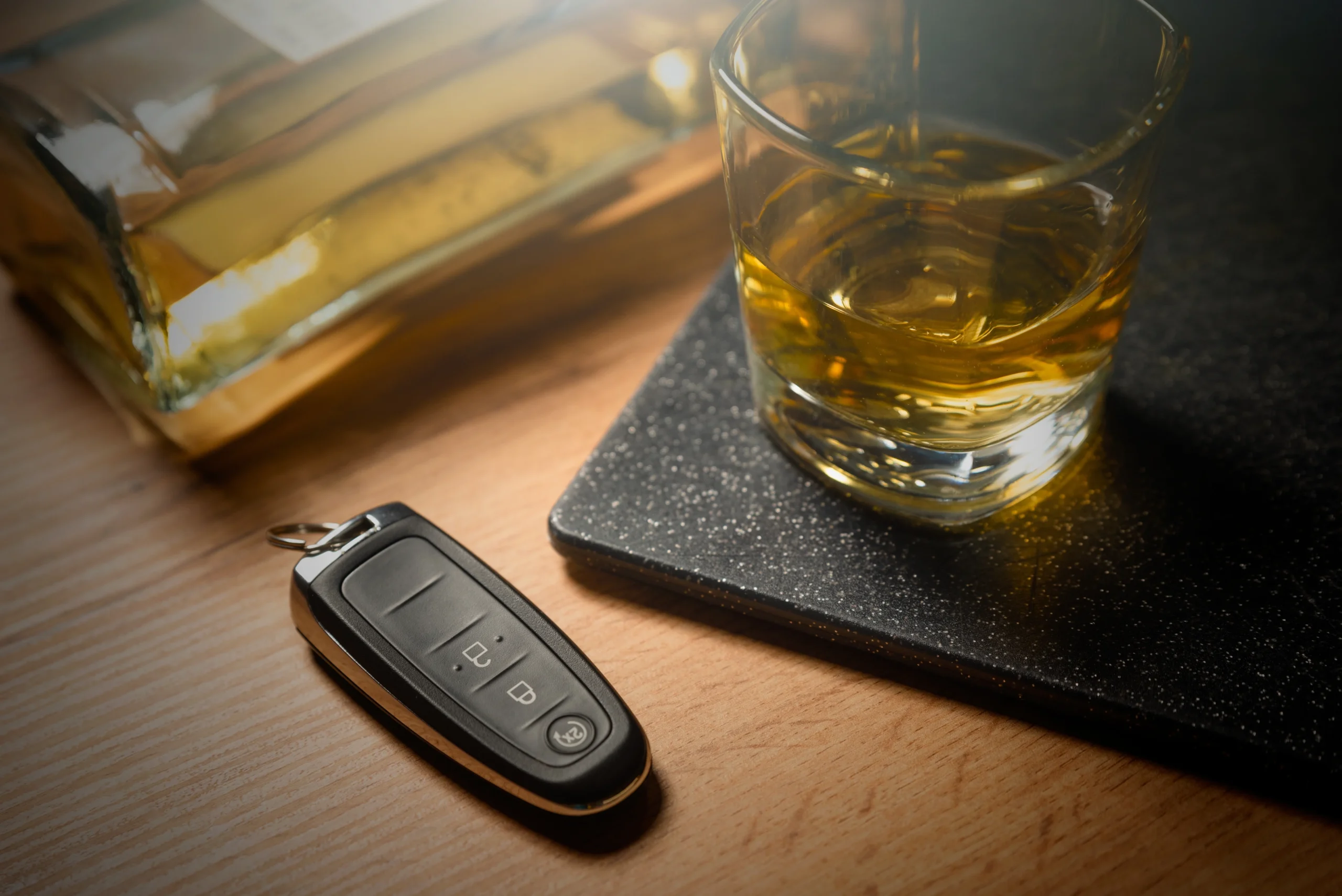 car key and a glass of alcohol on a table